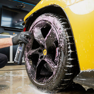 Applying AMMO Plum wheel cleaner to a car wheel